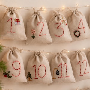 May include: A series of beige fabric drawstring bags hanging on a string, each embroidered with a red number and a small festive icon. The bags are arranged in rows, featuring stitched designs like a gift, flower, wreath, tree, and lantern.
