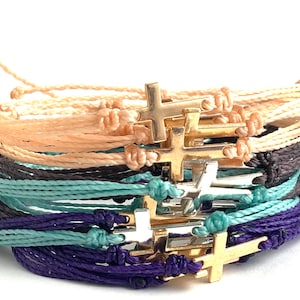 colors shown are blush peach with a gold cross, charcoal black with a silver cross, mint with silver cross and purple with gold cross.