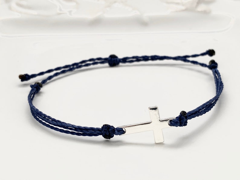Silver cross with navy blue straps