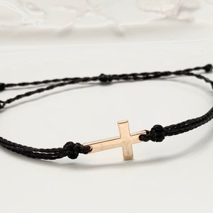 gold cross with black straps
