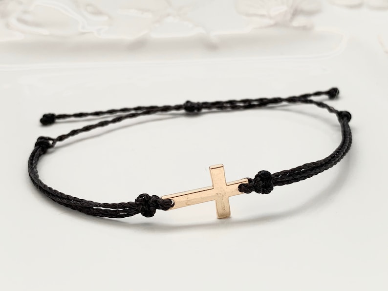 gold cross with black straps