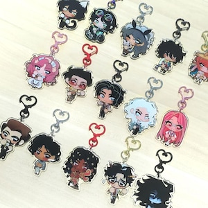 May include: A collection of anime-style character keychains with various designs. Each keychain features a unique character with detailed facial features, hair, and outfits. The keychains have metal heart-shaped clasps and are attached to a clear acrylic base.