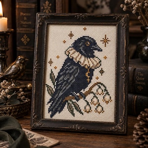 May include: A cross-stitch embroidery in a dark ornate frame depicting a dark blue bird with a white ruffled collar perched on a branch with white bell-shaped flowers. The bird is surrounded by small gold-coloured four-pointed star icons.