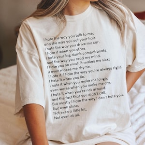 Op de afbeelding: Crèmekleurig T-shirt met een zwart gedrukt gedicht. Het gedicht begint met "I hate the way you talk to me..." en gaat verder met verzen over liefde en haat. Een casual kledingstuk voor dagelijks gebruik.