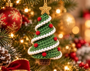 May include: A crocheted Christmas tree ornament featuring a green cone-shaped body with white spiral trim, small red spherical accents, a brown base, and a gold-colored star topper, suspended by a gold string.