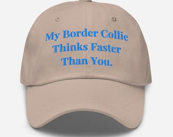 May include: A beige baseball cap featuring the blue embroidered text: "My Border Collie Thinks Faster Than You." The cap has a curved peak and an adjustable strap at the back.