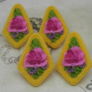 Puede incluir: Cuatro pendientes amarillos en forma de diamante con flores rosas y moradas y hojas verdes.