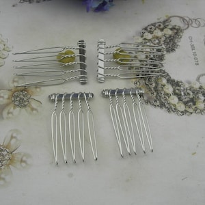 May include: Four silver hair combs in different styles. Two have multiple long tines and a twisted central bar. The other two have shorter tines. The combs are on a light surface with floral and beaded accents. The combs are suitable for bridal or formal hairstyles.