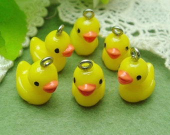 May include: Six yellow rubber duck charms with silver jump rings. The ducks have black eyes and orange beaks.