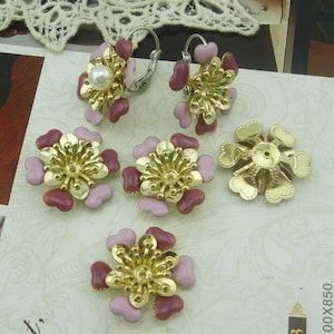 Può includere: Sei decorazioni dorate a forma di fiore con smalto rosa e bordeaux. Due delle decorazioni hanno chiusure per orecchini e una ha un retro piatto.