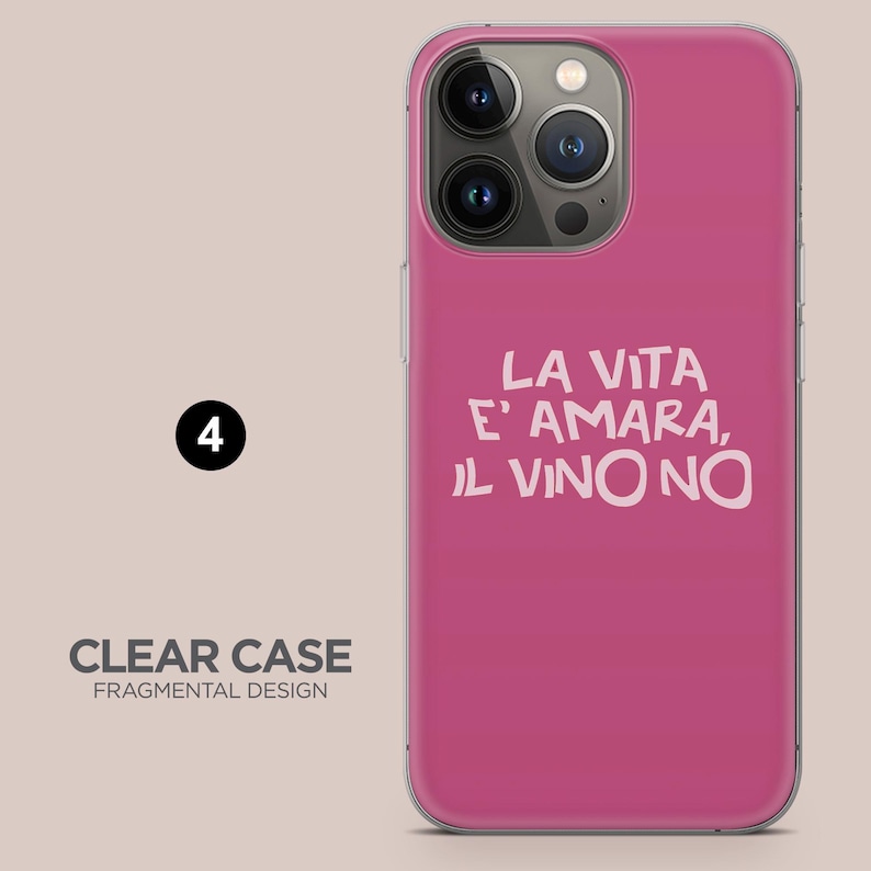 May include: A magenta iPhone case with the text "LA VITA E' AMARA, IL VINO NO" in white. The case has a clear border and a Fragmental Design label. The phone's camera lenses are visible.