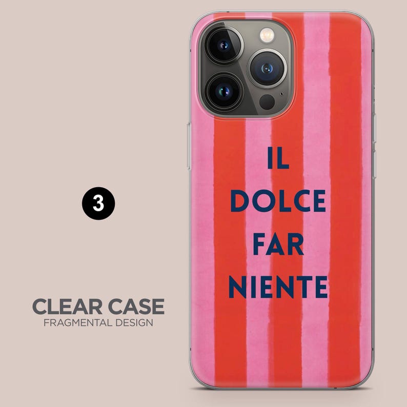 May include: Clear phone case with a vertical striped design in shades of pink and red. The case features the text "IL DOLCE FAR NIENTE" in navy blue. The words "CLEAR CASE FRAGMENTAL DESIGN" are also visible.