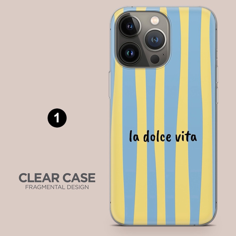May include: Clear phone case with a blue and yellow striped design. The words "la dolce vita" are written in black script. The case also has the words "CLEAR CASE FRAGMENTAL DESIGN".