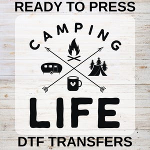 May include: Black and white camping-themed graphic with the words "READY TO PRESS" and "DTF TRANSFERS" at the top and bottom. The design includes a campfire, tent, camper, and mug with a heart. The word "CAMPING" arches above the design, and "LIFE" is below.