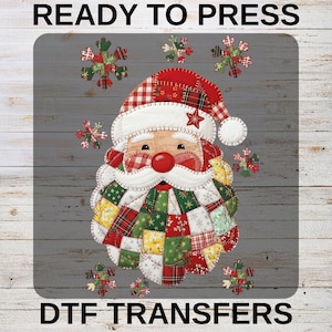 May include: A colorful Santa Claus design with a red and white plaid hat and a patchwork beard and coat. The image includes the text "READY TO PRESS" at the top and "DTF TRANSFERS" at the bottom. Decorative snowflakes are scattered around the Santa image.