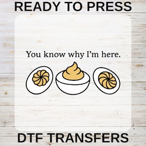 May include: DTF transfer design featuring deviled eggs. The image includes the text "READY TO PRESS", "You know why I'm here.", and "DTF TRANSFERS". The deviled eggs are white with yellow filling and a black outline.