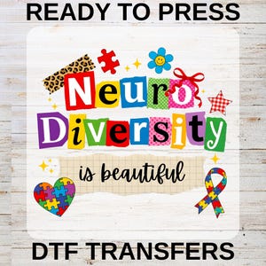 May include: A vibrant DTF transfer design featuring the phrase "Neuro Diversity is beautiful." The design incorporates puzzle pieces, a flower, a ribbon, and a star. The words "READY TO PRESS" and "DTF TRANSFERS" are also included.
