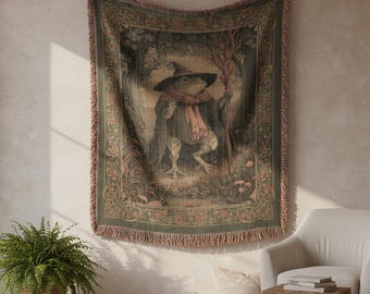 May include: Woven tapestry featuring a whimsical illustration of a frog dressed as a wizard, wearing a hat and scarf, holding a staff. The tapestry has a green and brown color scheme with a floral border and fringe.