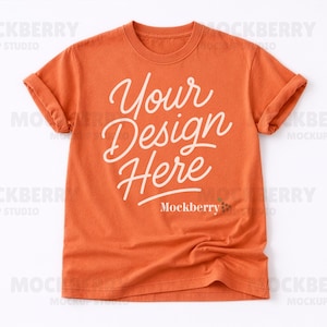 May include: Orange t-shirt with rolled-up sleeves. The shirt features the text "Your Design Here" in a cursive font. The Mockberry logo is at the bottom of the shirt.