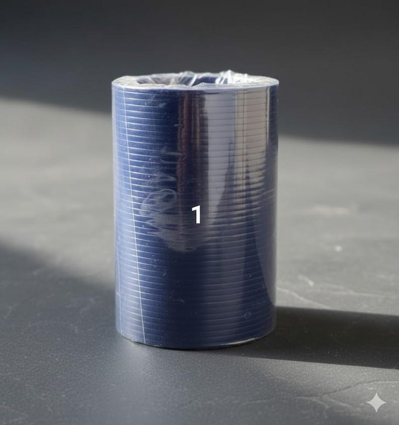 K&ouml;nnte beinhalten: Eine zylindrische Rolle aus marineblauem Material, verpackt in klarem Kunststoff. Die Zahl "1" ist wei&szlig; auf der Vorderseite aufgedruckt. Das Material hat eine gerippte Textur und ist eng gewickelt.