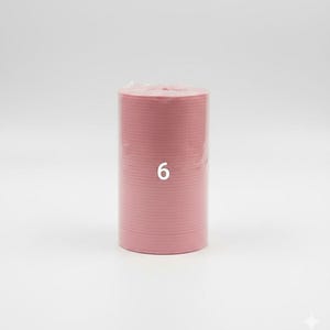 K&ouml;nnte beinhalten: Ein Stapel rosa Pappteller, verpackt in klarem Kunststoff. Die Zahl "6" ist auf die Seite des Stapels gedruckt. Die Teller haben eine einfarbige, hellrosa Farbe.