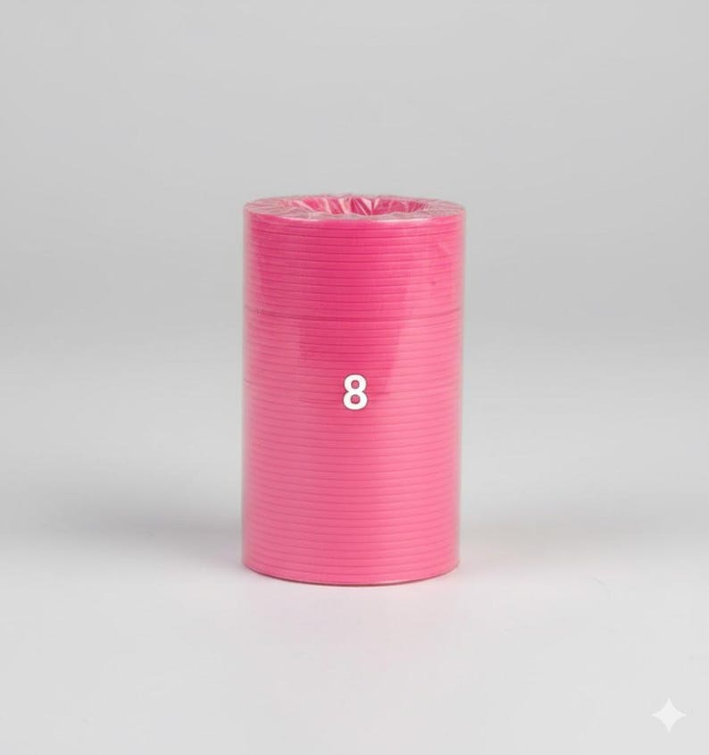 K&ouml;nnte beinhalten: Eine zylindrische Rolle aus leuchtend rosa Material, m&ouml;glicherweise Band oder Kordel, wird vor einem schlichten Hintergrund gezeigt. Die Zahl "8" ist wei&szlig; auf der Vorderseite der Rolle aufgedruckt. Das Material scheint eng gewickelt zu sein.