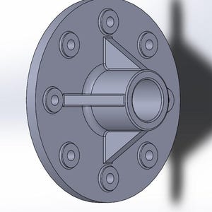 May include: A gray, circular mechanical component with a central cylindrical opening and six smaller circular openings around the perimeter. The component has a series of triangular and rectangular structural supports.