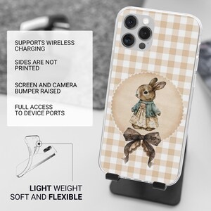 May include: A clear phone case with a tan and white gingham pattern. The case features a circular illustration of a bunny wearing a dress and a bow. The text on the case reads: Supports Wireless Charging, Sides Are Not Printed, Screen and Camera Bumper Raised, Full Access to Device Ports, Light Weight, Soft and Flexible.