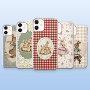 Puede incluir: Cinco fundas para teléfono con ilustraciones de conejos. Los diseños incluyen estampados florales, cuadros vichy y marcos ovalados con retratos de familias de conejos. Cada funda tiene un borde transparente.