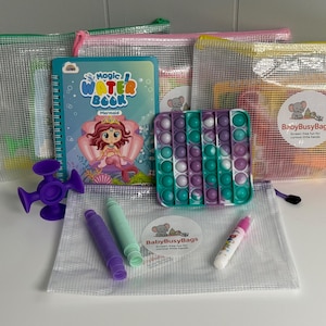 May include: A collection of children's activity sets, including a mermaid-themed water book, a pop-it toy, and crayons. The sets are packaged in clear zippered pouches with colorful zippers. A purple suction toy and a sticker are also visible.