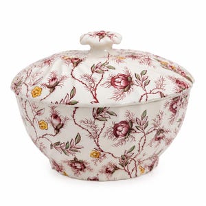 May include: A white ceramic lidded serving bowl with a floral design. The pattern includes red roses, green leaves, and yellow flowers on a white base. The lid is topped with a flower-shaped handle.