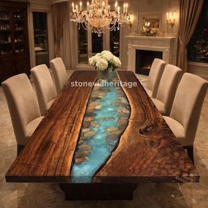 May include: A large, rectangular wooden dining table with a river-like design. The center features a blue epoxy resin filled with stones. The table is surrounded by beige chairs and set in a luxurious dining room with a chandelier.