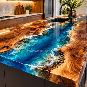 Op de afbeelding: Een keukeneiland-werkblad met een houten blad met natuurlijke rand en een centraal rivierontwerp van blauwe hars, dat oceaangolven met wit schuim nabootst. Het oppervlak is glanzend, met de tekst stoneviaheritage zichtbaar.