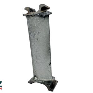May include: A worn metal turbine blade, featuring a rectangular base and a notched top. The blade has a long, curved shape with a textured surface, indicating use. This component is likely from an aircraft engine, showing signs of wear.