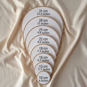 A series of embroidery hoop sizes, ranging from 31 cm to 10 cm, with each hoop labeled with its corresponding size.