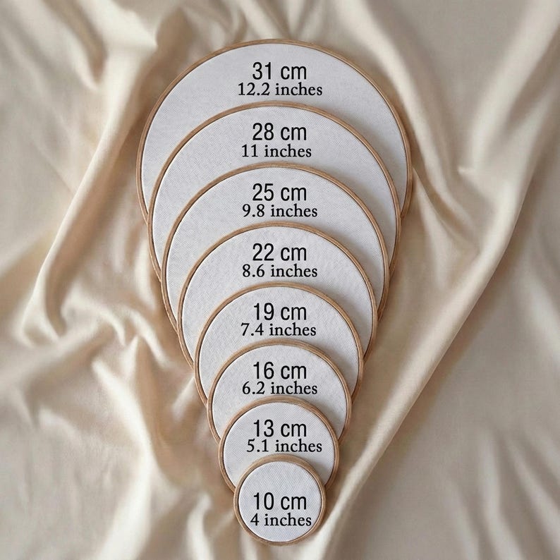 A series of embroidery hoop sizes, ranging from 31 cm to 10 cm, with each hoop labeled with its corresponding size.