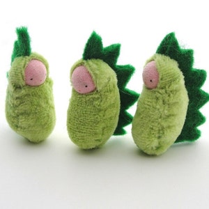 May include: Three small plush toys shaped like green peas with pink faces and green felt spines.