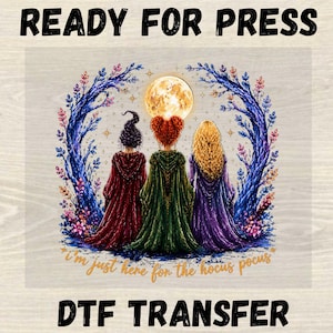 May include: A DTF transfer featuring three figures in hooded cloaks of red, green, and purple standing before a full moon and blue trees. The text reads READY FOR PRESS at the top, DTF TRANSFER at the bottom, and i'm just here for the hocus pocus below.