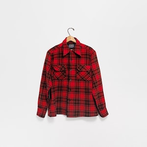 May include: A red and black plaid button-down shirt with two chest pockets hangs on a wooden hanger. The shirt has a classic collar and long sleeves. The plaid pattern is a bold combination of red and black, creating a striking visual.