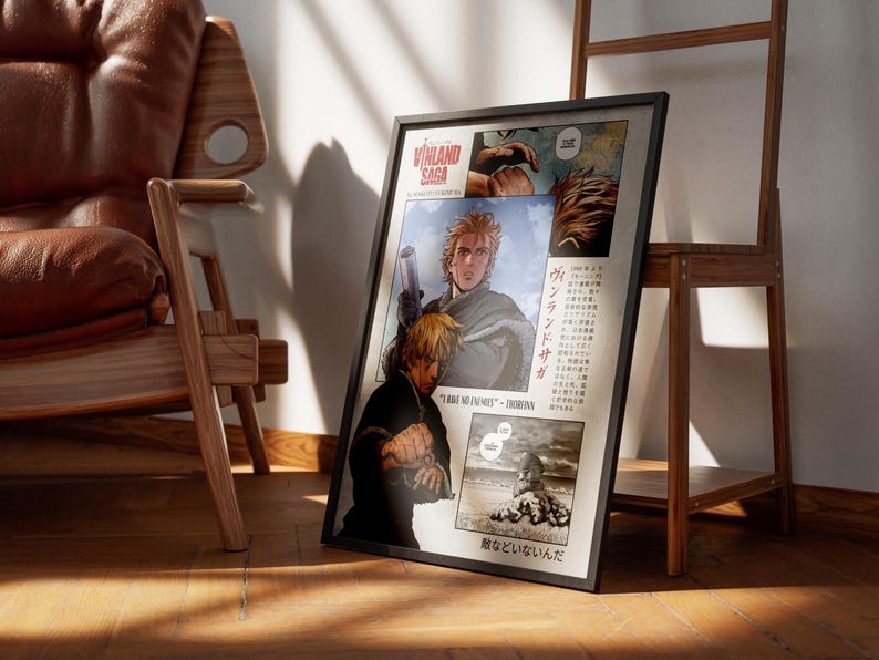 May include: Framed poster featuring panels from the manga series Vinland Saga. The artwork depicts characters with blonde hair and action scenes. Text in English and Japanese is visible. The poster is leaning against a wooden shelf.