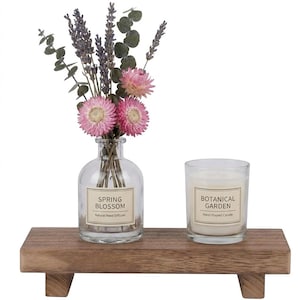 May include: A wooden tray holds a clear glass vase with dried flowers and a candle in a glass. The vase has a label that reads "Spring Blossom, Natural Reed Diffuser." The candle has a label that reads "Botanical Garden, Hand Poured Candle."