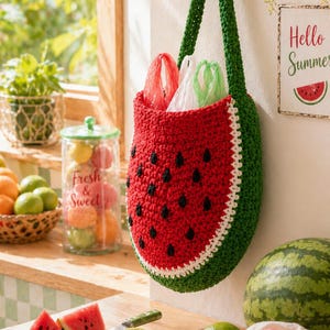 May include: A handmade crochet watermelon-shaped bag with a green handle, red body, black seed details, and white trim. The bag is hanging on a wall. The image also includes a watermelon, limes, and a sign that says "Hello Summer".