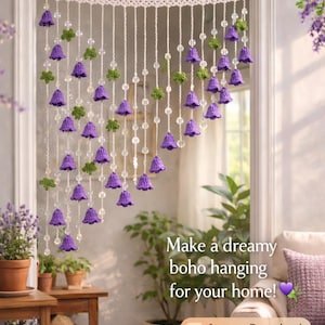 Puede incluir: Un patrón de cortina de ganchillo con flores de campana lavanda y hojas verdes. La cortina está suspendida de una parte superior de ganchillo blanca. El texto dice "Make a dreamy boho hanging for your home!" y "Instant Download, Beginner-Friendly, Cottagecore Home DIY."