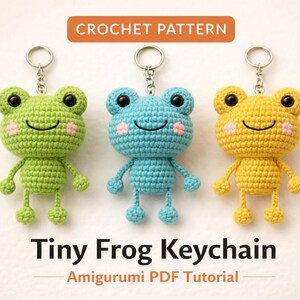 May include: Three crochet frog keychains in green, blue, and yellow. Each frog has black eyes, a smiling mouth, and pink cheeks. The keychains are attached to silver metal rings. Text at the top says "CROCHET PATTERN". Below the frogs, the text reads "Tiny Frog Keychain".