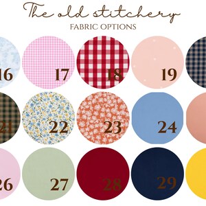 Puede incluir: Una tabla de muestras de tela titulada The old stitchery FABRIC OPTIONS con quince muestras circulares numeradas. Los patrones incluyen flores azul claro, cuadros vichy rosas, cuadros vichy rojos, lunares rosa p&aacute;lido, cuadros azul marino, cuadros marrones, flores azules, flores naranjas y colores s&oacute;lidos.