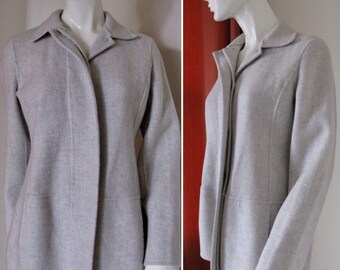 May include: A light gray, long-sleeved, collared jacket with a zipper closure. The jacket has a fitted silhouette and a slightly flared hem.