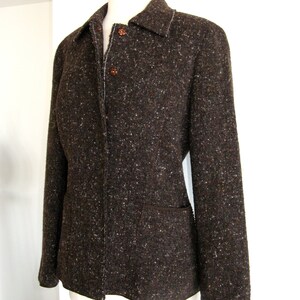 May include: A brown tweed jacket with a button-up front and a patch pocket on the left side.