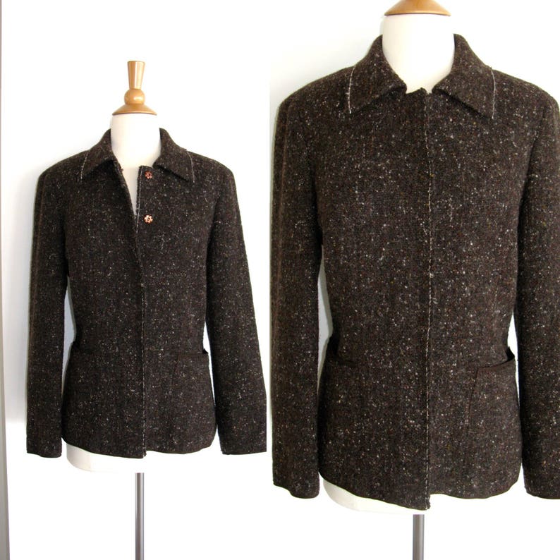 May include: A brown tweed jacket with a button closure and pockets. The jacket has a subtle speckled pattern.