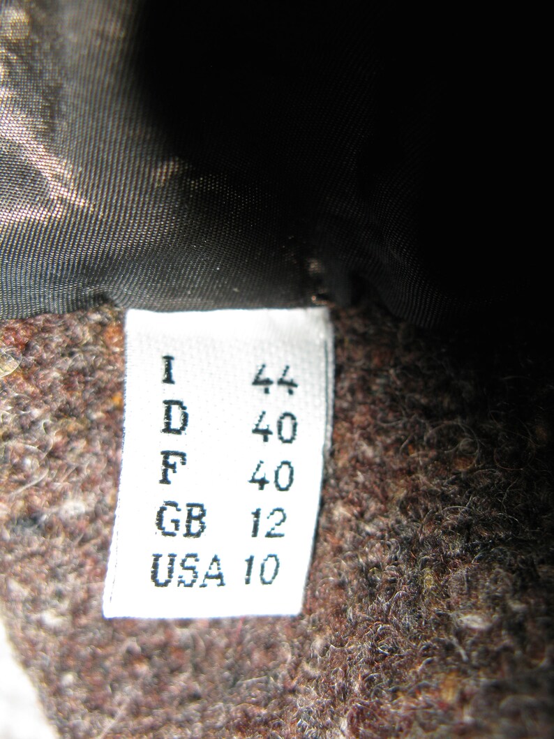 May include: White tag with black text indicating sizes in different countries: I 44, D 40, F 40, GB 12, USA 10.