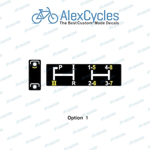 May include: Black decal with gear shift pattern, labeled P, R, I, and numbers 1-8. The decal also includes a smaller section with gear symbols. The text "AlexCycles" and "The Best Custom Made Decals" are also present.